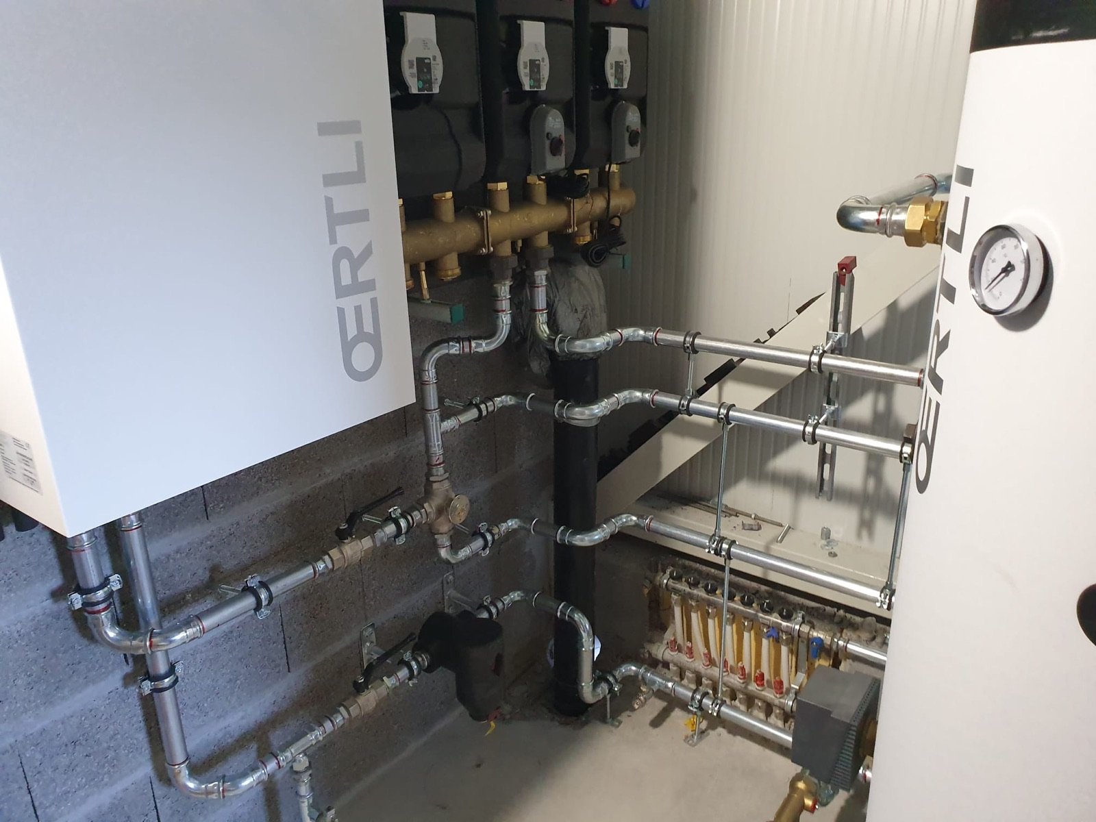 Installation d'une pompe à chaleur Oertli avec groupes de pompes, collecteurs et distribution de chauffage au sol